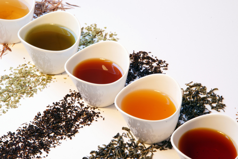 Small porcelain tea pots with different sorts of tea such as black tea, matcha tea, gunpowder tea, green tea, rooibos tea