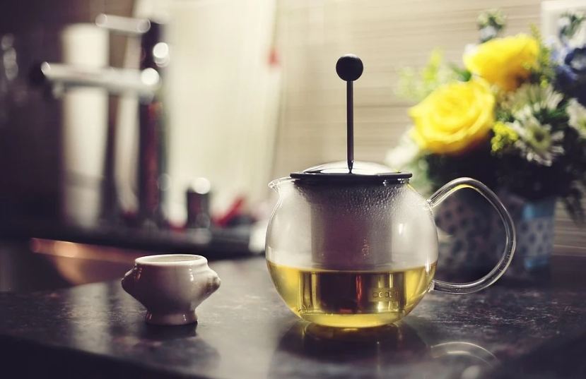 A cup and pot with green tea 