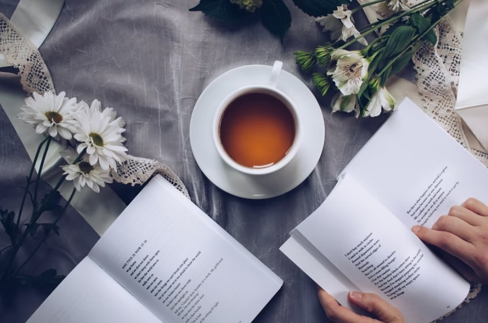 Image showing a cup of tea surrounded by books and flowers.