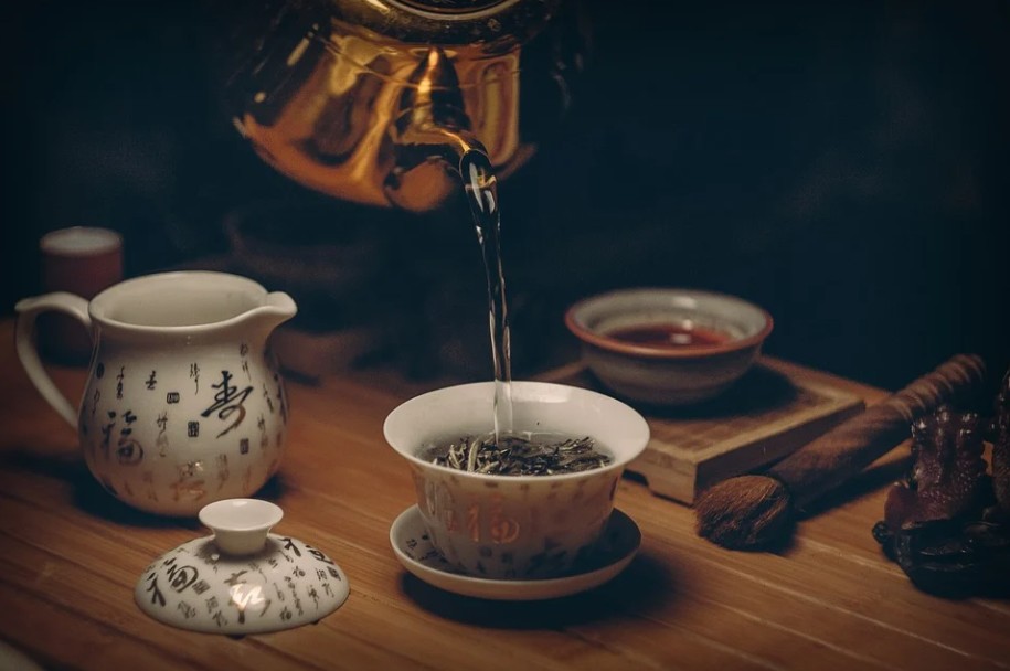 Image showing water being poured into a cup full of tea leaves.