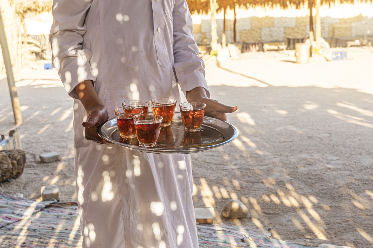 Bedouin welcome a cup of tea with almonds, Sinai. A tray with mugs of traditional Egyptian tea in the waiter's hand.