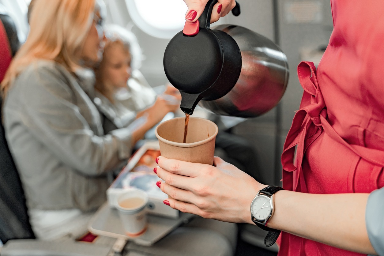 Air hostess is making coffee for passengers