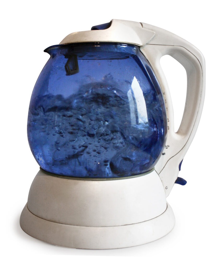 An electric kettle, with boiling water visible in its transparent water chamber